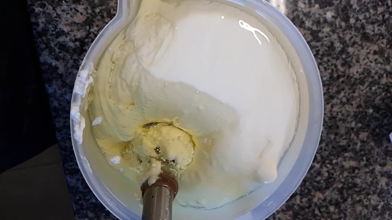 Blander olie og yoghurt med en stavblender i ultra slowmotion.