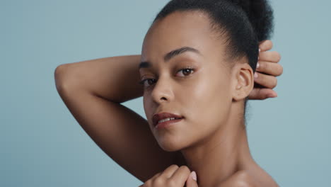 portrait healthy young woman touching face with hand caressing smooth skin complexion enjoying soft natural beauty on blue background skincare concept