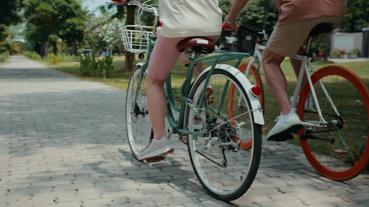 Legs of Man and Woman Riding Bicycle in Park