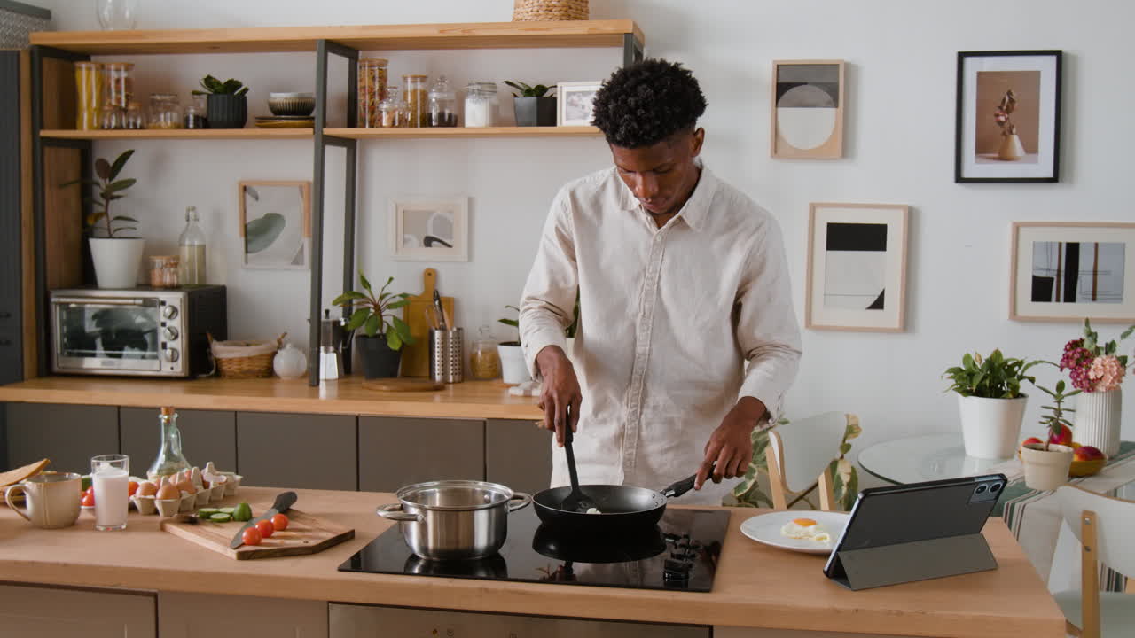 Man cooking eggs in the kitchen