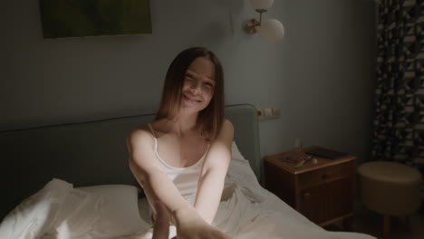 woman in bedroom holding hands