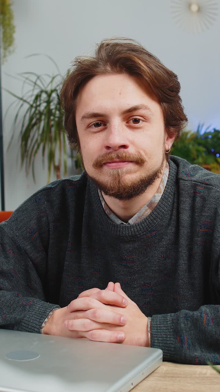 Giovane uomo freelance seduto sul divano vicino al PC portatile dopo aver terminato il lavoro in ufficio a casa