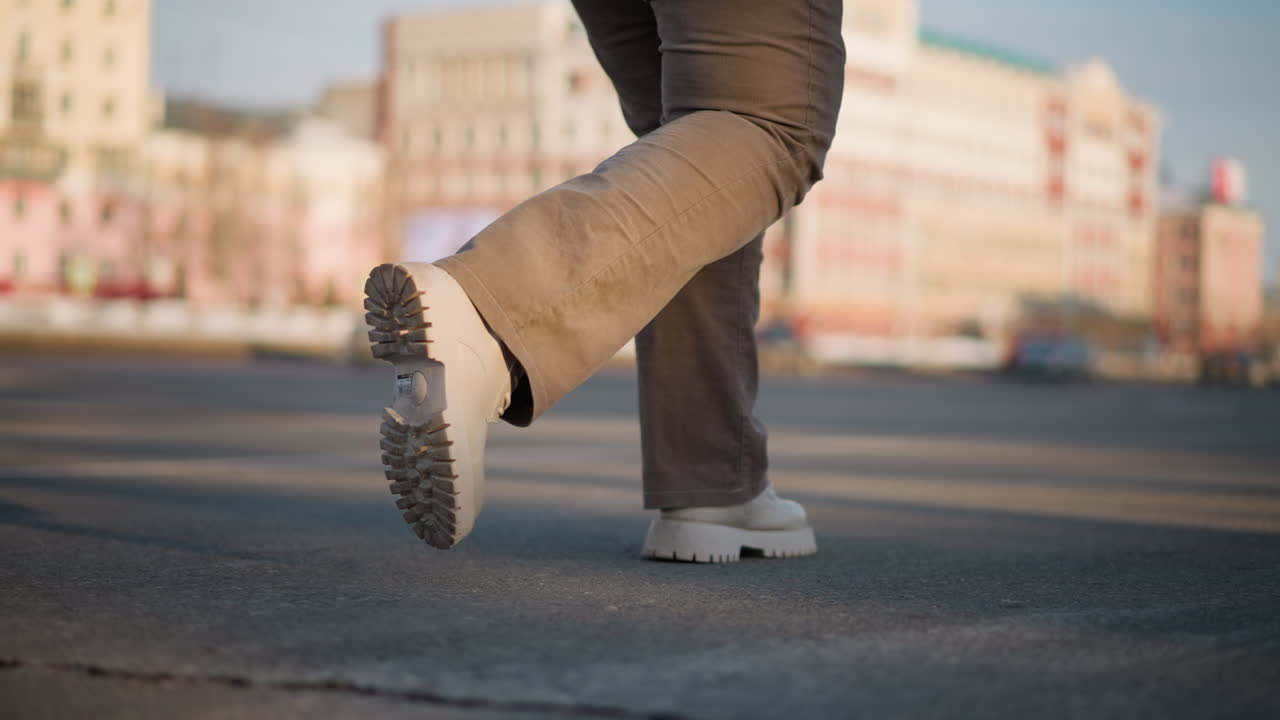 Creative tap dancer performs precise footwork on wet tiled pavement with melting snow at edges, sending water droplets flying under morning sunlight, capturing urban winter energy and rhythm