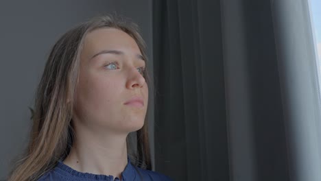 woman looking out through the window, closeup