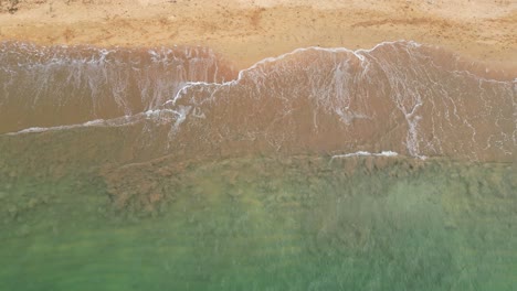 From-above-waves-crashing-at-a-desert-beach,-Africa