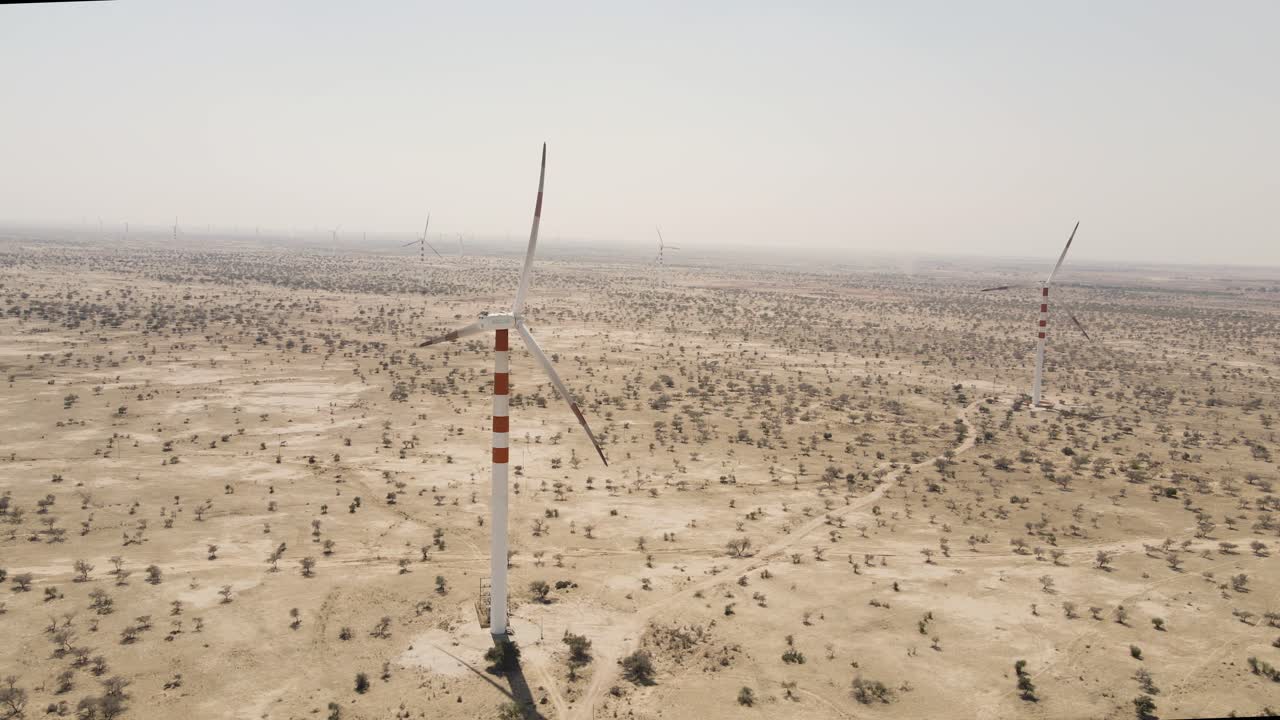 Aerial drone shot revealing windmills dotting the golden landscape of Rajasthan’s wind-blown desert plains.
