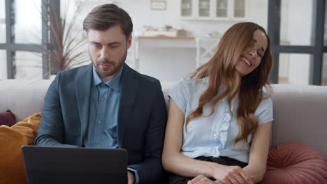 Family-discussing-business-in-home-office.-Couple-working-on-laptop-together.