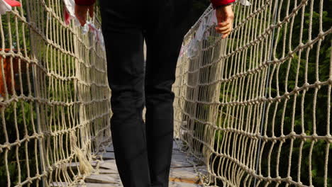 older women with backpack passing himalayan sidewalk path skywalk wooden construction with colored flags during windy, sunny autumn day captured in radhost pustevny area slow motion 4k 60fps