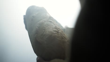 jesus christ in white robe and glowing light holding bread as a representation of the gospel and jesus as the bread of life in cinematic, dramatic slow motion.
