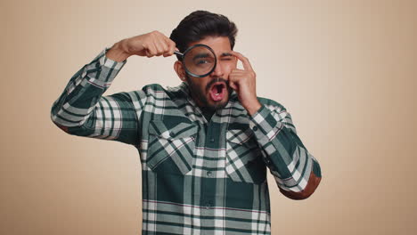 investigator researcher man with magnifying glass near face looking into camera with big zoom eye
