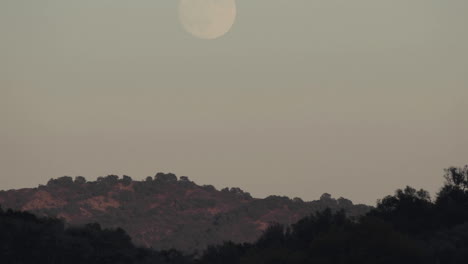 lapso de tiempo de la luna llena que se eleva sobre un paisaje en oak view california