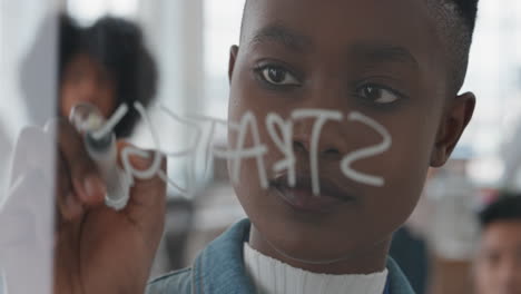 Junge-Afroamerikanische-Geschäftsfrau,-Teamleiterin,-Die-Auf-Dem-Whiteboard-Schreibt,-Schulungskollegen-Austauscht-Ideen-Zur-Problemlösung-Im-Präsentationsseminar-Im-Büro