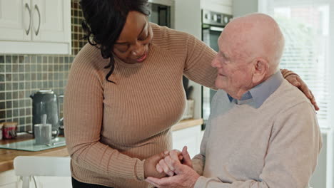 a caregiver comforting an elderly man in a kitchen