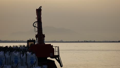 sacks of sea salt waiting at santa pola´s port to be loaded next to a crane