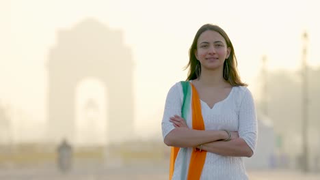 chica india confiada de pie en la puerta de la india con las manos cruzadas en un vestido indio