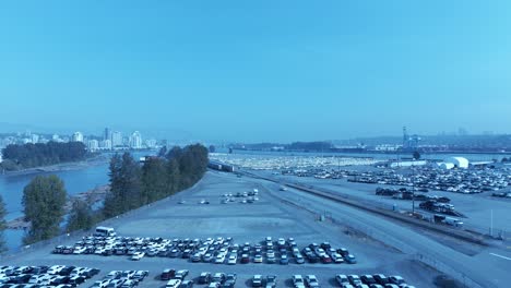 Estacionamiento-De-Automóviles-Sobrevuelo-Aéreo-De-La-Isla-De-Mitchell-Cargueros-Del-Río-Fraser-Atracan-Para-Exportar-E-Importar-Vehículos-En-Un-Día-Soleado-De-Verano-En-Una-Propiedad-Comercial-Segura-Jk-Japonés-Usado-Y-Auto-Nuevo-Fuera-De-Knight-St