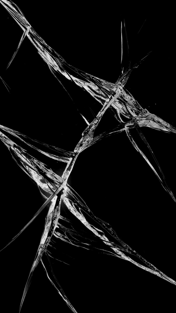 Singola grande crepa su schermo di vetro su sfondo nero, loop continuo, formato verticale