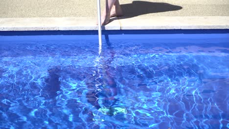 man cleaning vacuuming pool sunny day