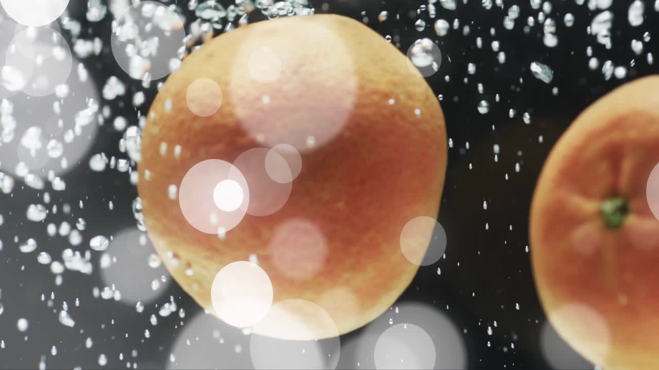 검은 바탕에 물에 떠있는 오렌지 위의 색 빛의 점의 구성