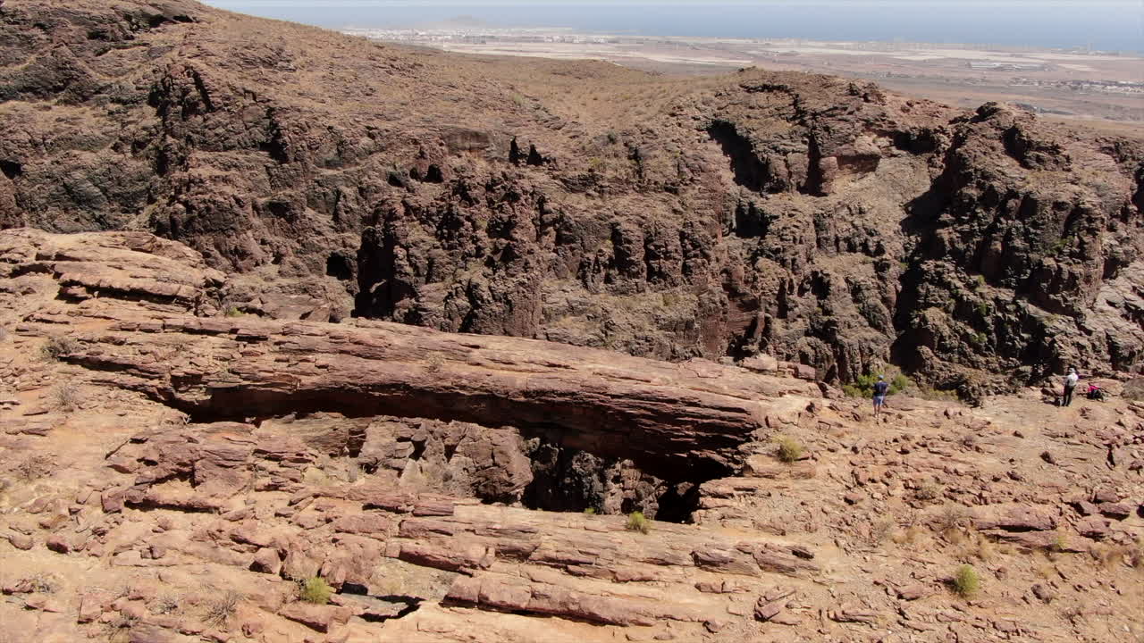 toma aérea de un par de turistas mirando desde el arco del coronadero