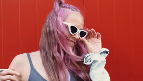 mujer elegante con cabello rosa y gafas de sol