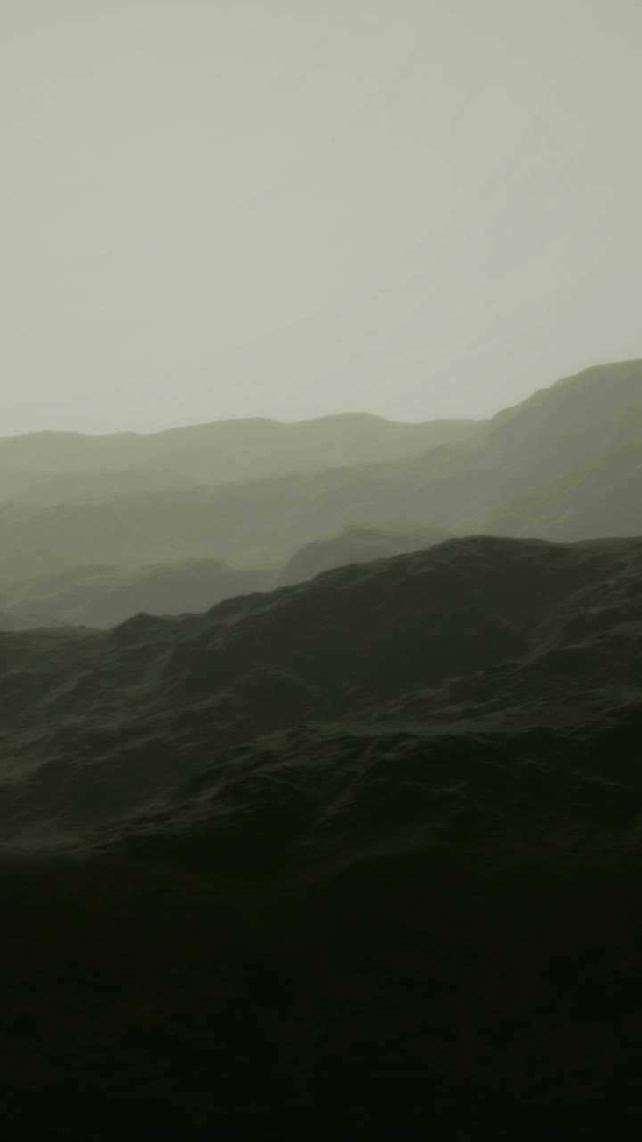 Misty mountain range enveloped in soft hues during early dawn