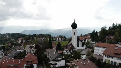 rising aerial view over the rural homes in oberbozen, italy