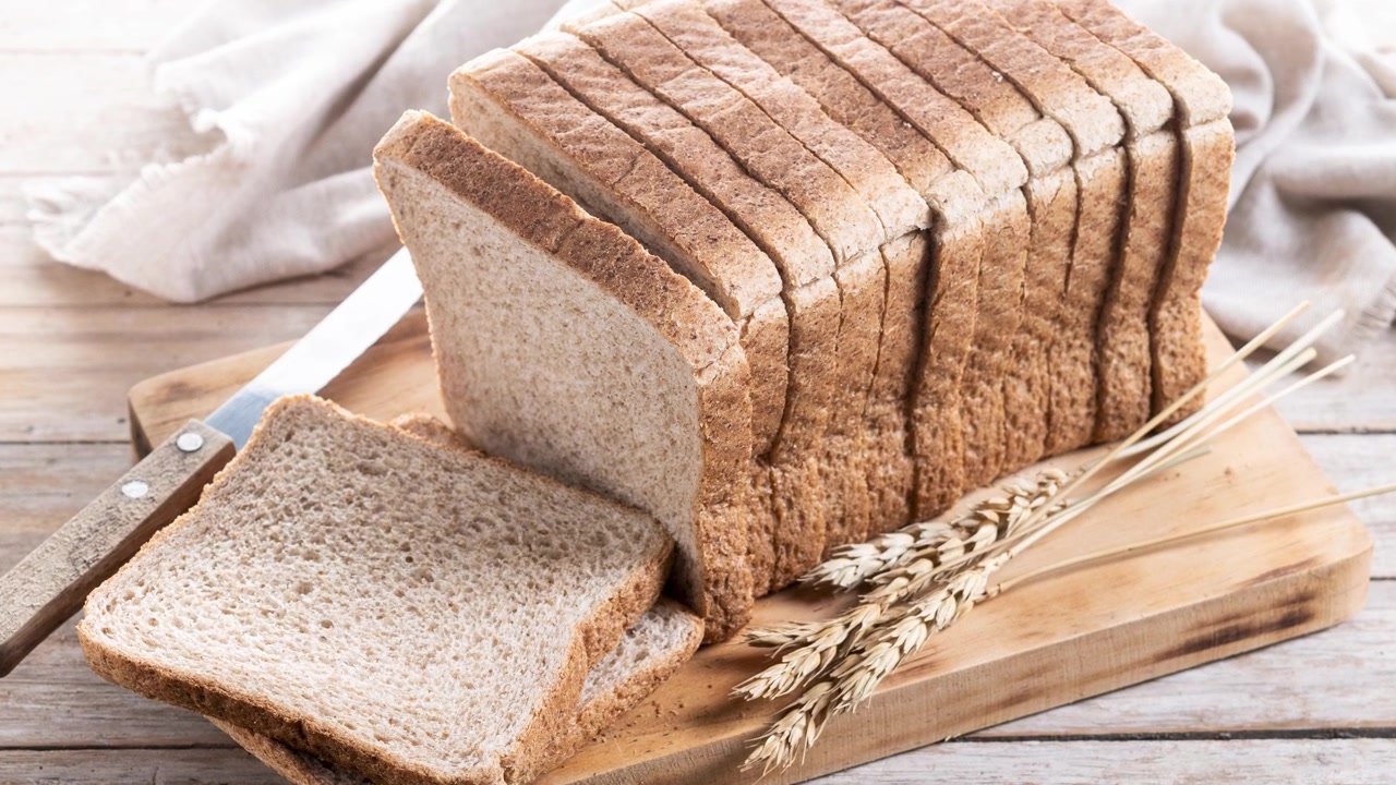 Sliced Whole Wheat Bread Loaf on Wooden Cutting Board