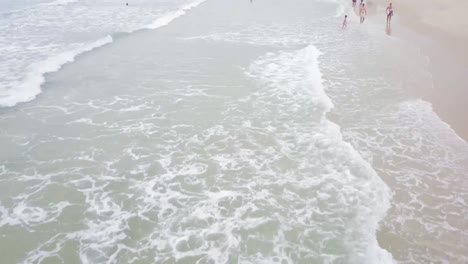 dron aéreo moviéndose hacia adelante y revelando la playa en un día nublado