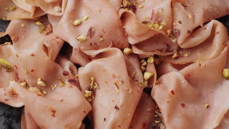 ham italian mordatella, man slices of traditional italian antipasti mortadella sausage on a wooden cutting board, close up macro of chicken or turkey jamon, fat breakfast dish.