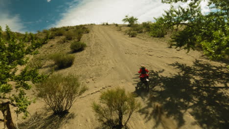 rider enjoys motorcycle trip in hilly valley fpv drone. inspired racer rides competing for championship in desert racing. motocross sports event