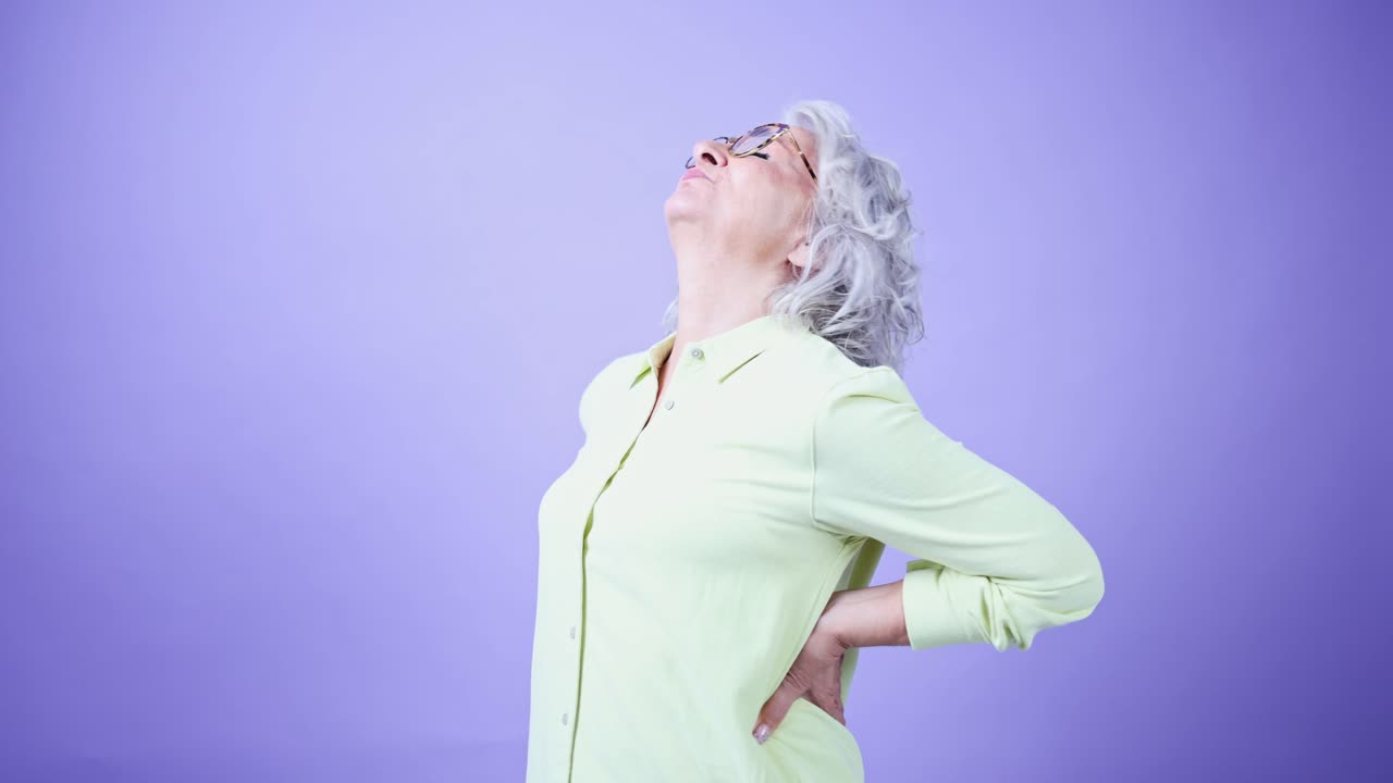 Senior Woman Stretching Her Back to Relieve Pain