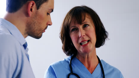 médicos discutiendo sobre una tableta digital en el pasillo
