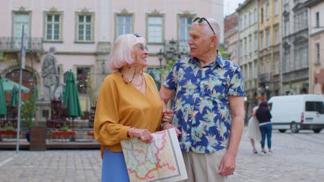 Senior-couple-grandmother-and-grandfather-tourists-talking-having-conversation-on-street-in-old-city