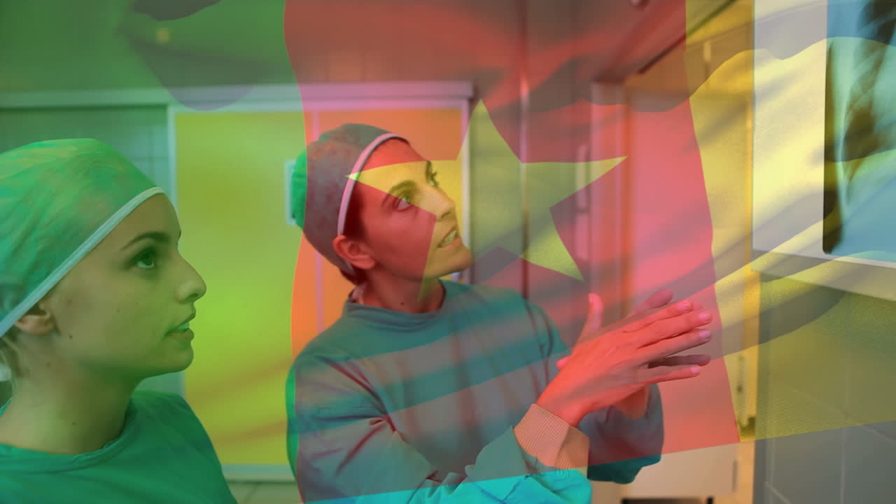 Animation of flag of cameroon over caucasian female doctors talking