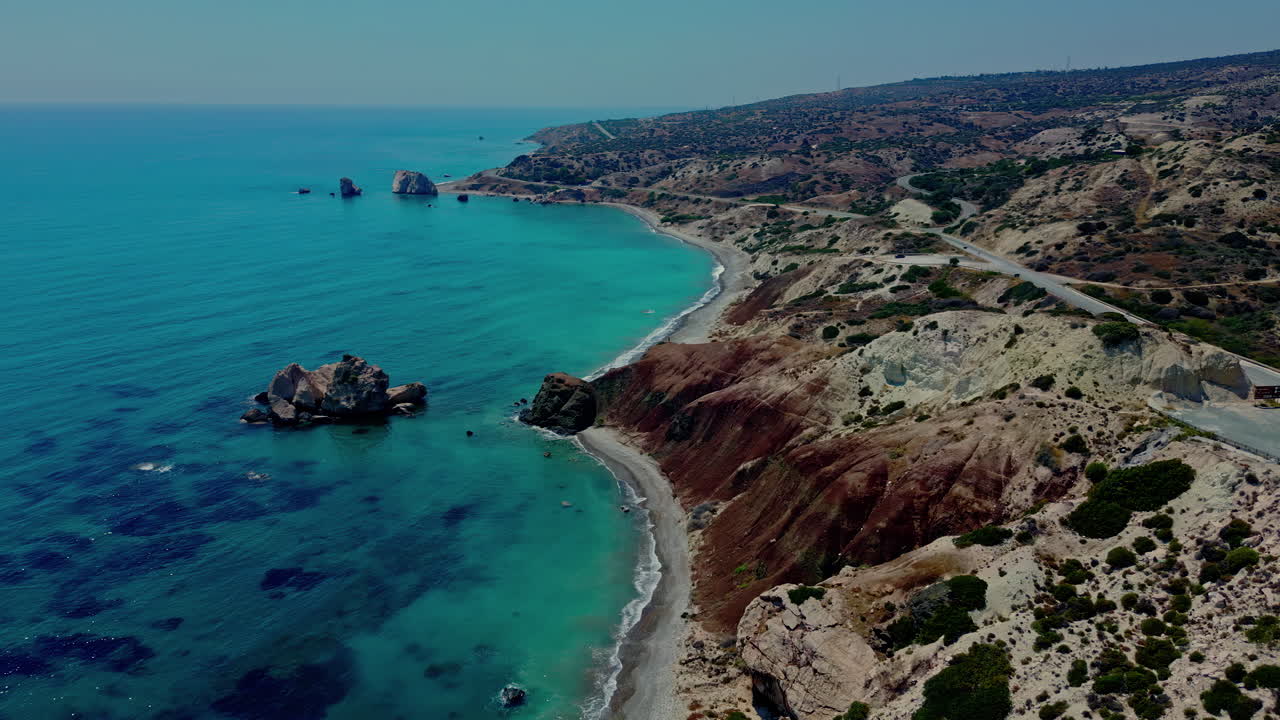 el avión no tripulado vuela sobre la costa de la roca afrodita con aguas cristalinas y azules del mediterráneo por debajo.