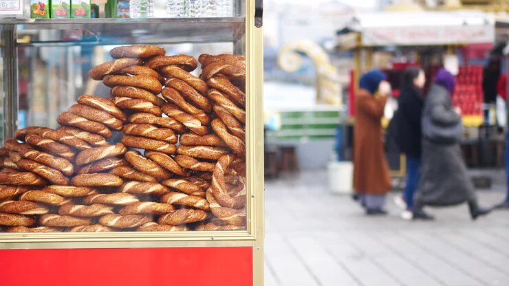 türkischer straßenkostverkäufer, der simit verkauft