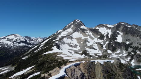 Pan-De-Azúcar-Con-Pinos-Nevados-Y-Cielo-Azul-Brillante-En-Las-Cordilleras-Del-Pacífico-Canadá-BC-4k---Toma-Aérea-Lateral-De-Drones