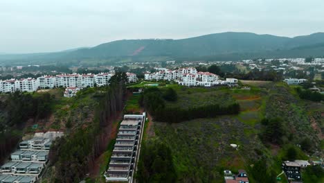 Aerial-view-of-exclusive-homes-and-buildings-on-the-coast-overlooking-the-sea-in-the-wealthy-community-of-Maitencillo,-Chile