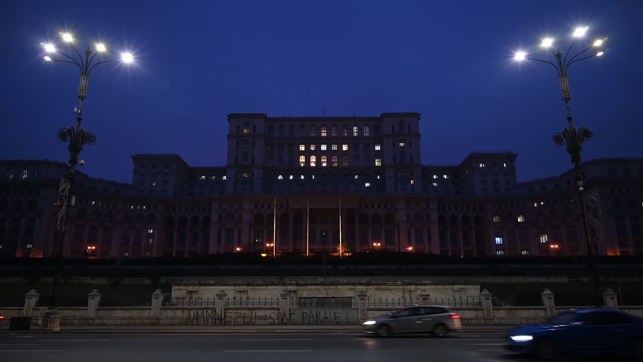 Bucharest, Romania - January 10, 2020: Cars moving in front of the Palace of Parliament building in the evening