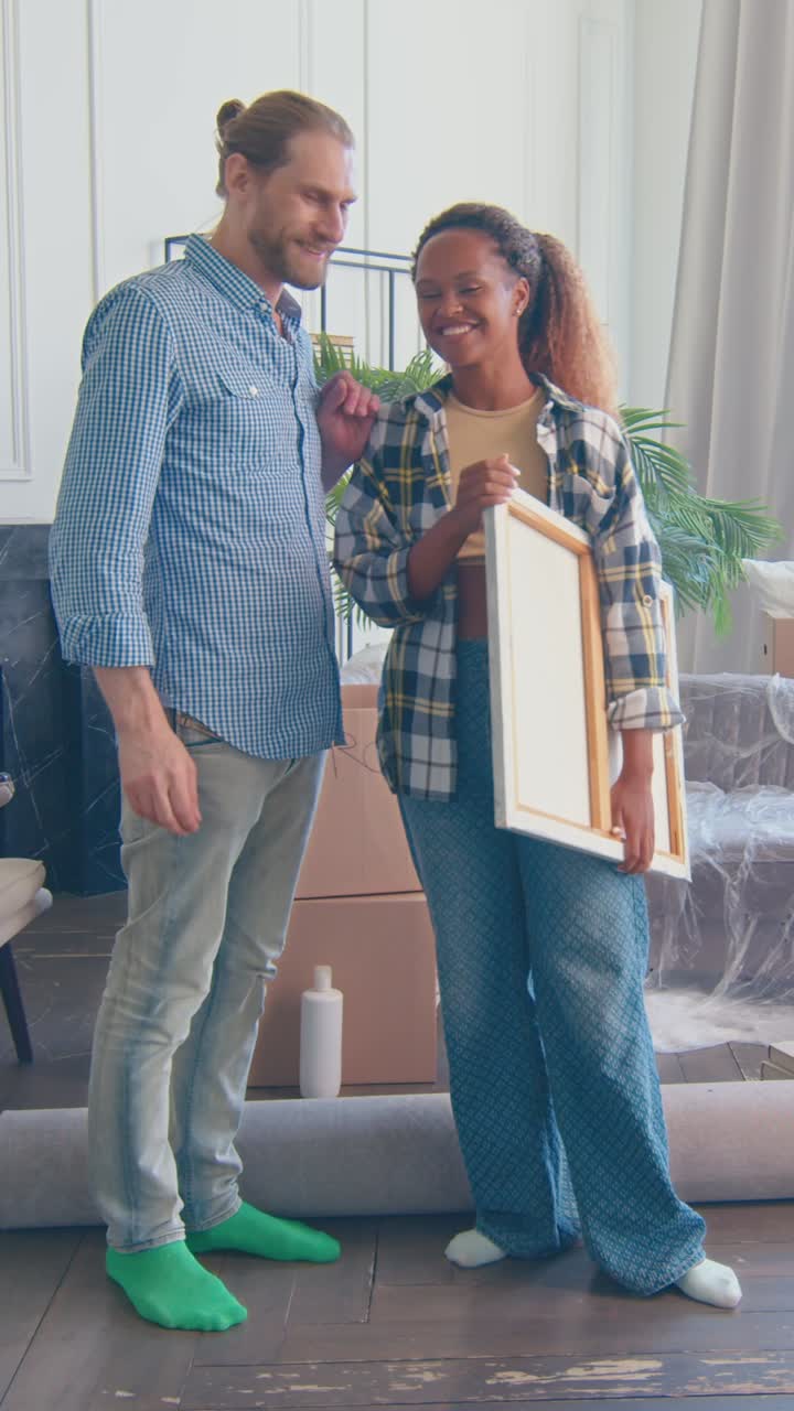 Diverse couple moves into new home and begins decorating