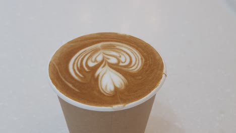 Eine-Tasse-Kaffee-Auf-Weißem-Tisch,-Cappuccino-Heißer-Kaffee-In-Pappbecher