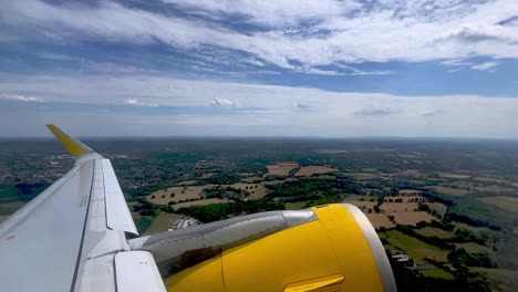 passenger point of view of yellow jet commercial airplane wing and engine during takeoff from london gatwick airport