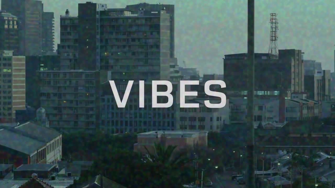 Animazione del testo "vibes" in bianco con effetto pixel su pellicola di paesaggio urbano