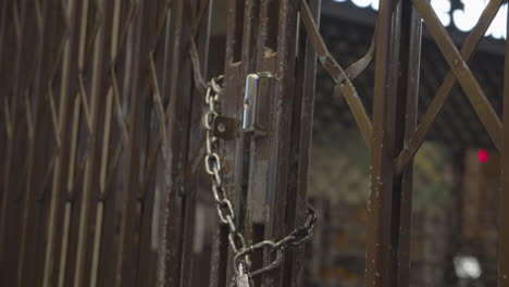 puerta de celosía de hierro cerrada con cadena de metal y candado