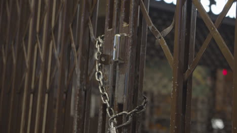 iron lattice door locked with metal chain and padlock