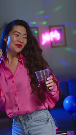 Vertical-Video-Of-Long-Haired-Woman-Having-Fun-Dancing-And-Drinking-Alcohol-At-House-Party-2