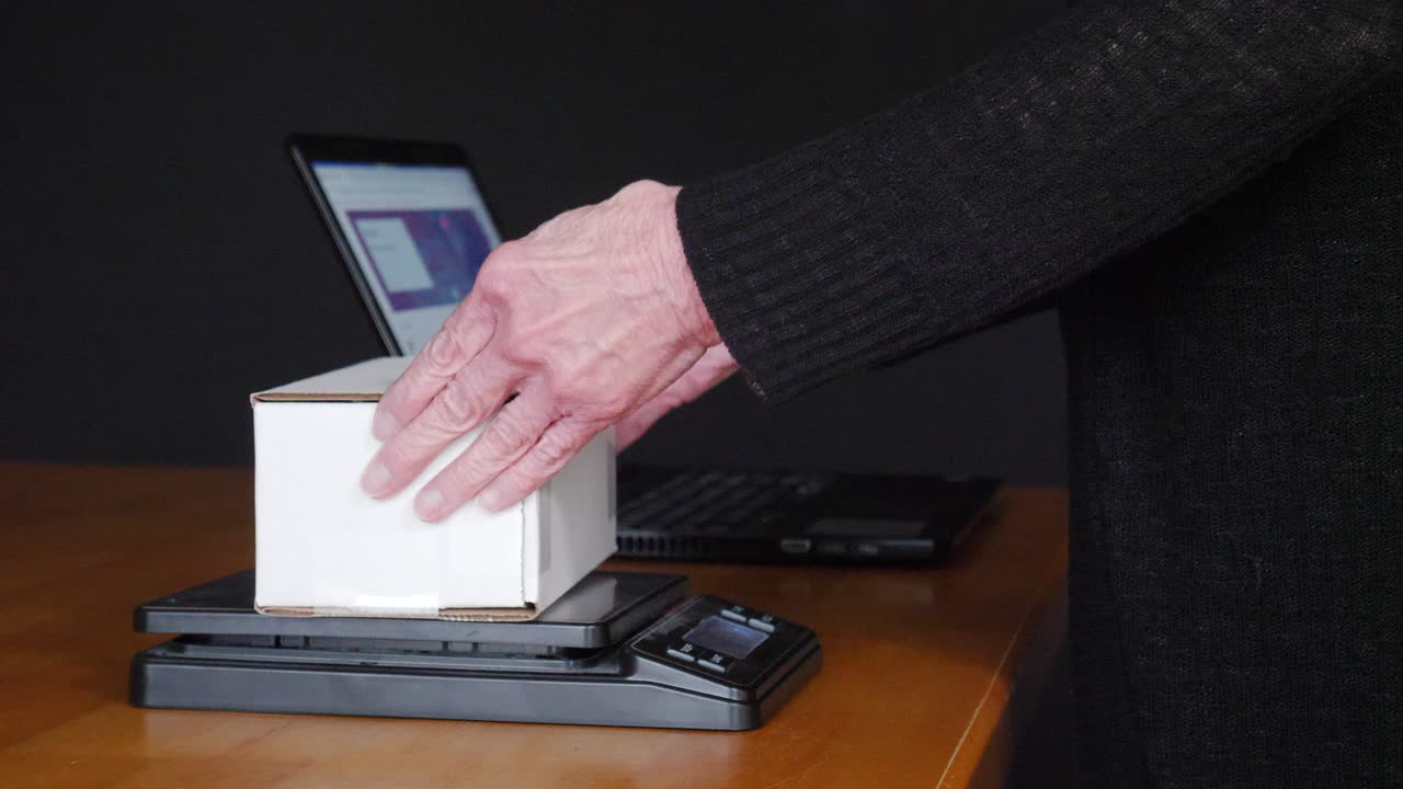 pesaje, embalaje y envío de un artículo vendido en línea en una caja de cartón con envoltura de burbujas a un cliente desde un sitio web de comercio electrónico de subasta