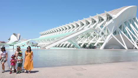 tourists pose in front of the science museum within the city of arts and sciences complex, the most important modern tourist destination in valencia, designed by santiago calatrava and félix .