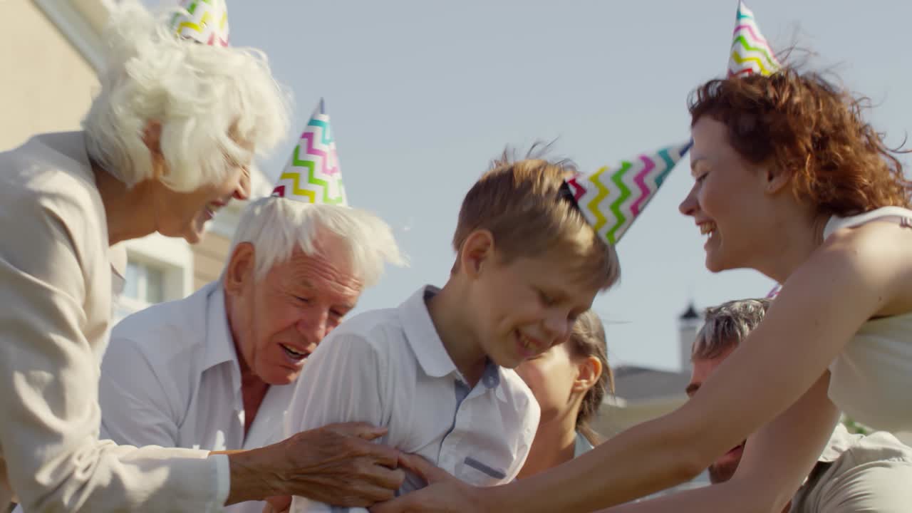 Familie danst en viert de verjaardag van een kleine jongen buiten